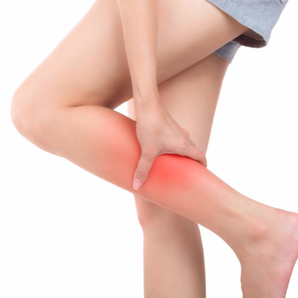 Woman with calf feeling pain on white background